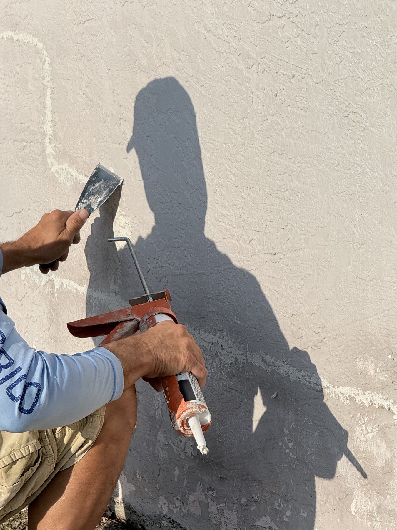 Drej360 team member applying patch material to exterior stucco